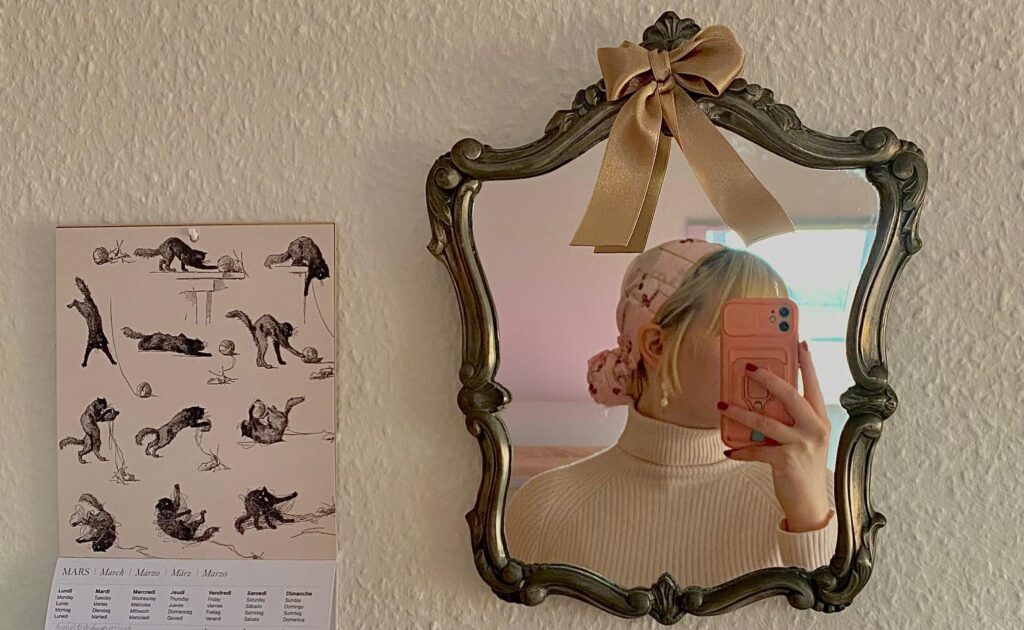 Ästhetisches BIld mit einem alten Zinnspiegel. Frau mit Tuch als Kopfschmuck.